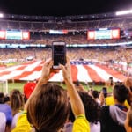 People at football stadium holding up their phones