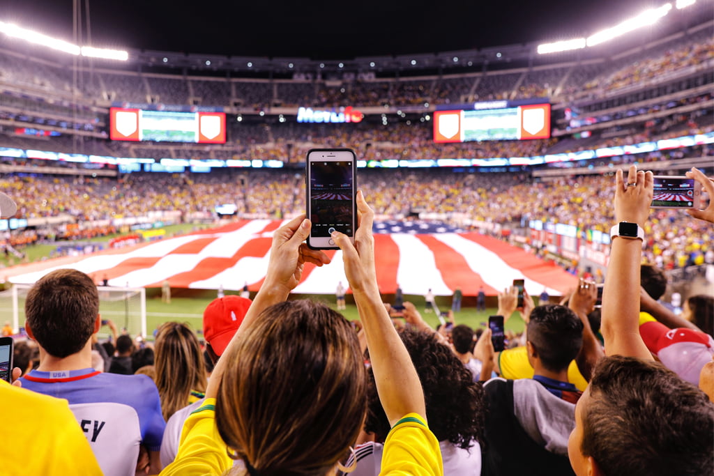 People at football stadium holding up their phones