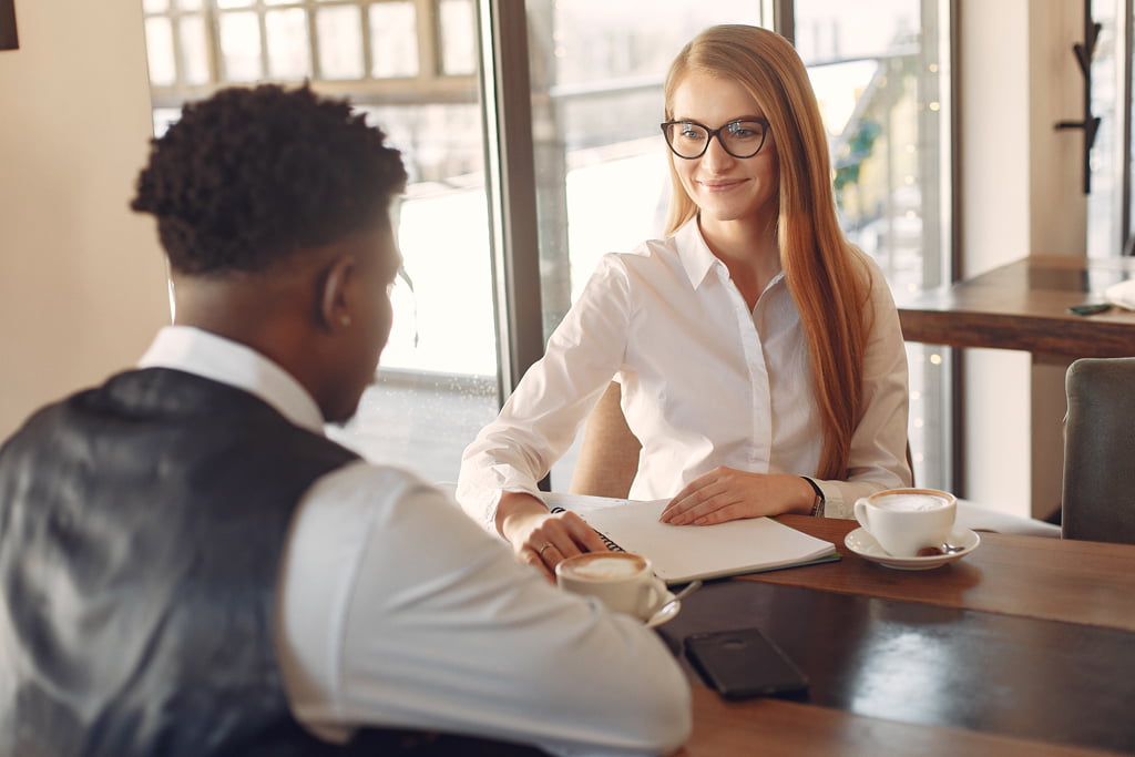 Man and woman sat in a coffee shop having a job interview